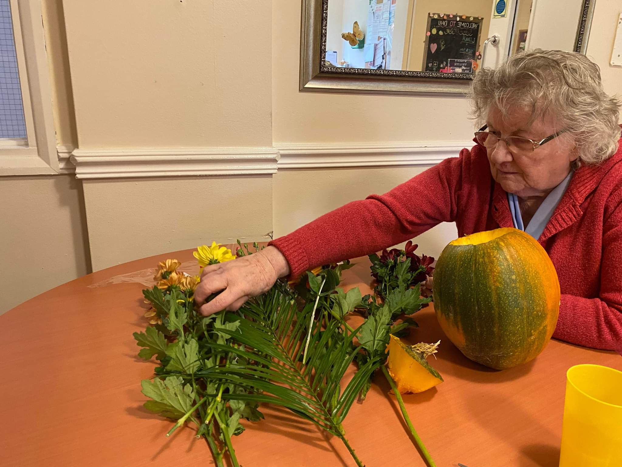 resident picking flowers to go in her pumpkin