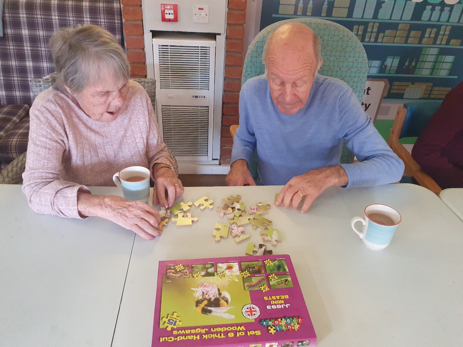 residnets enjoying a jig saw puzzle with their morning coffee