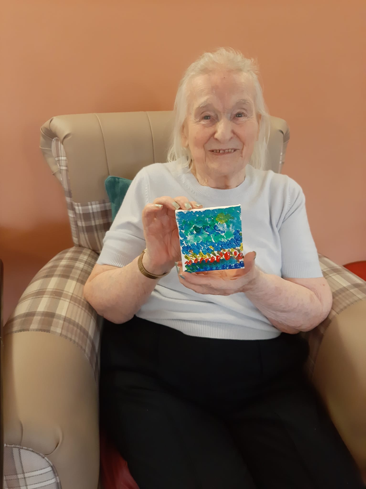 Resident with her mini canvas that she has painted 