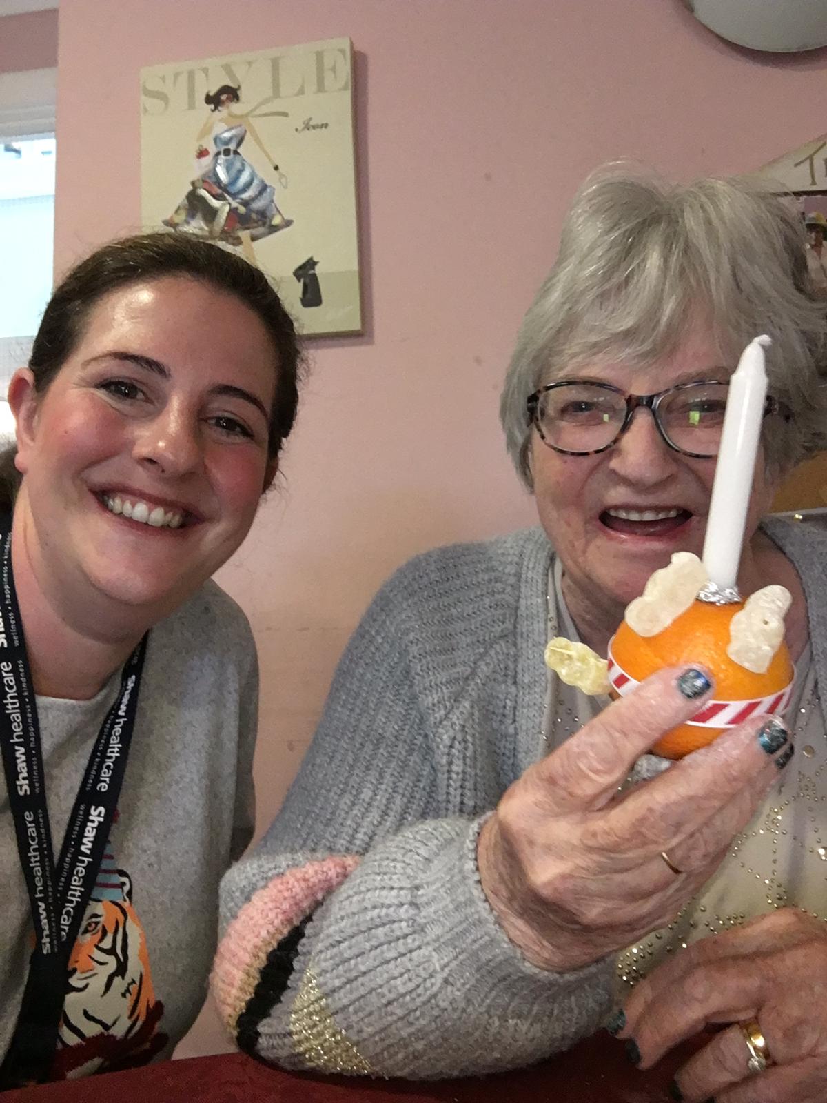 resident and employee with Christingle 