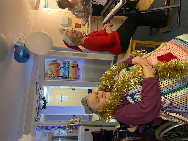 resident with tinsel listening to Christmas songs