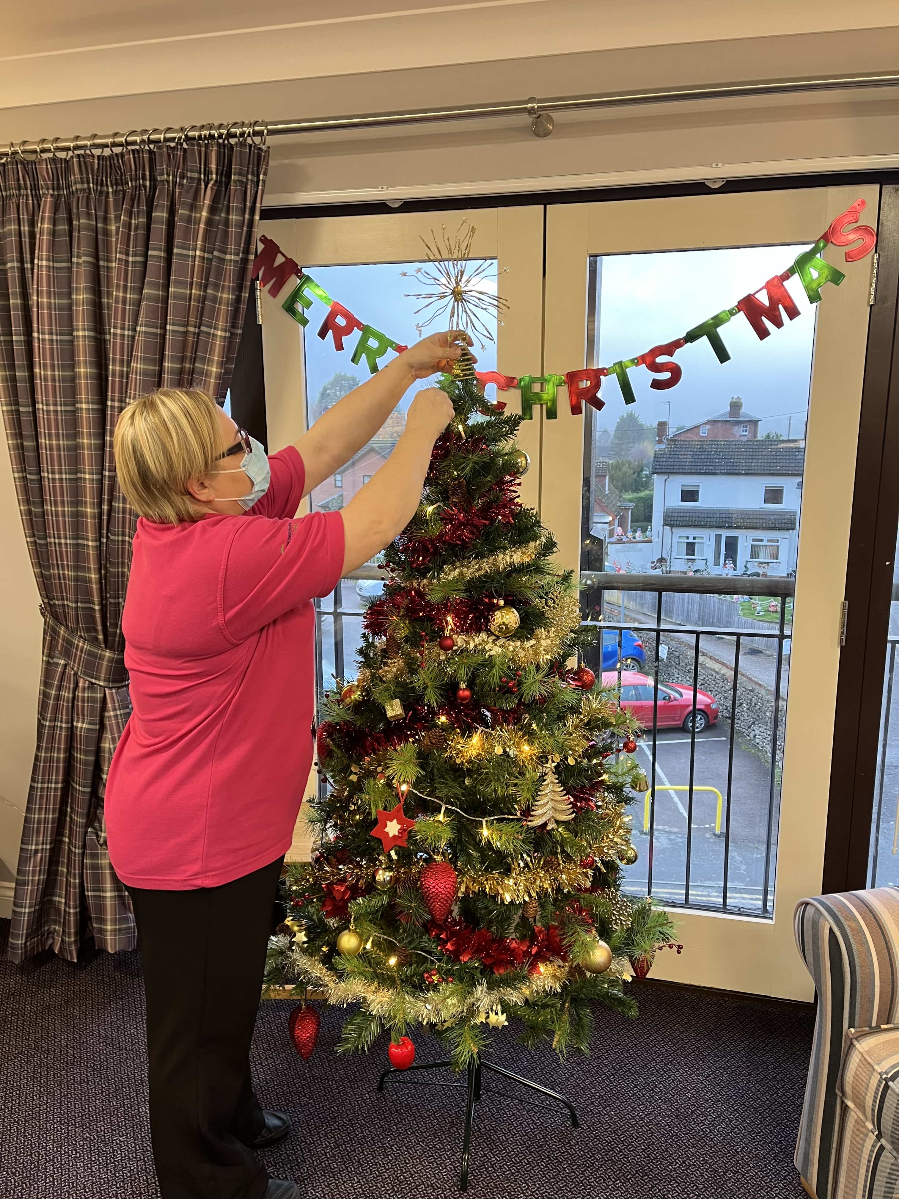 employee decorating the Christmas tree