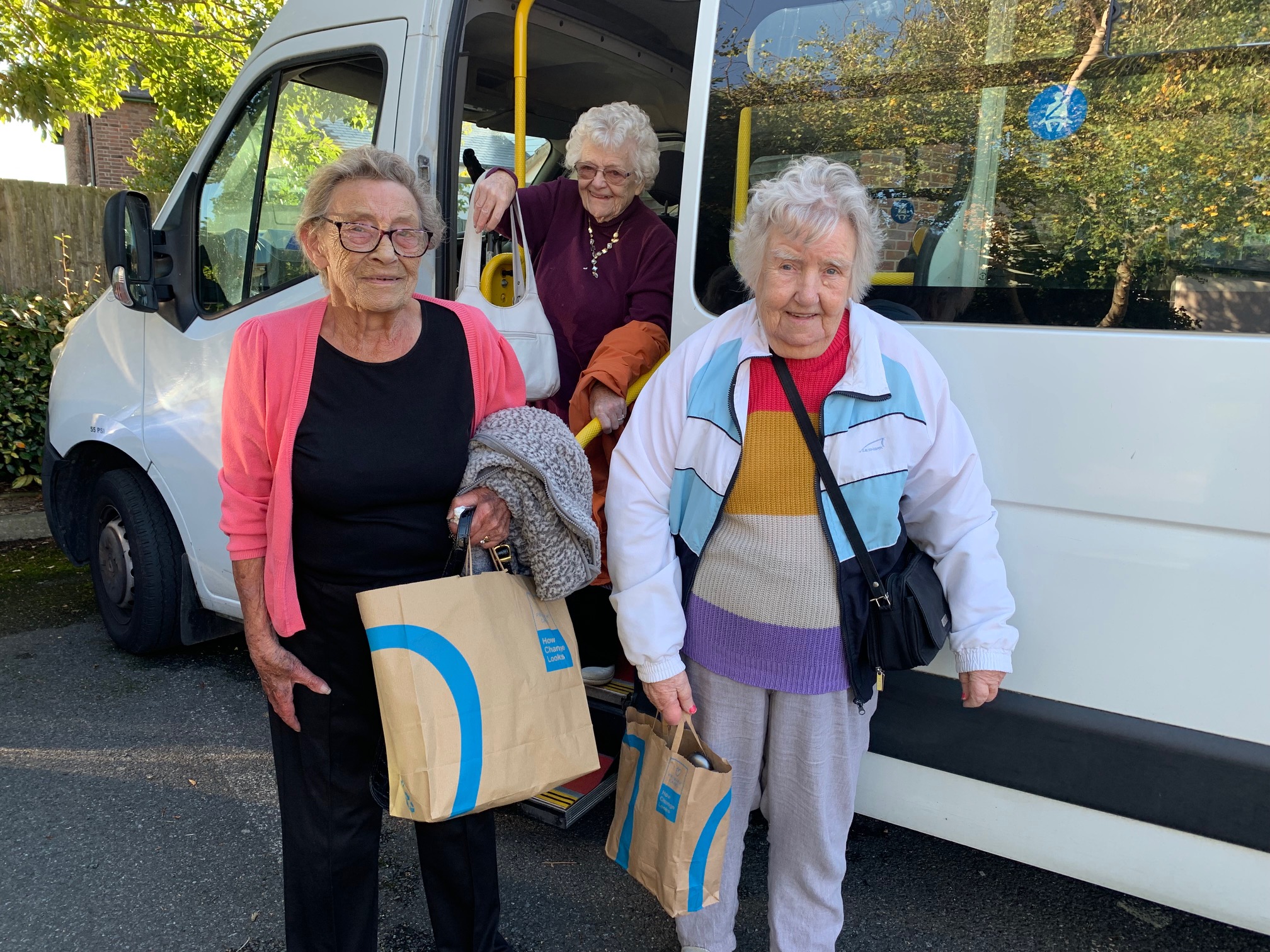 Three residents getting out of mini bus to go shopping