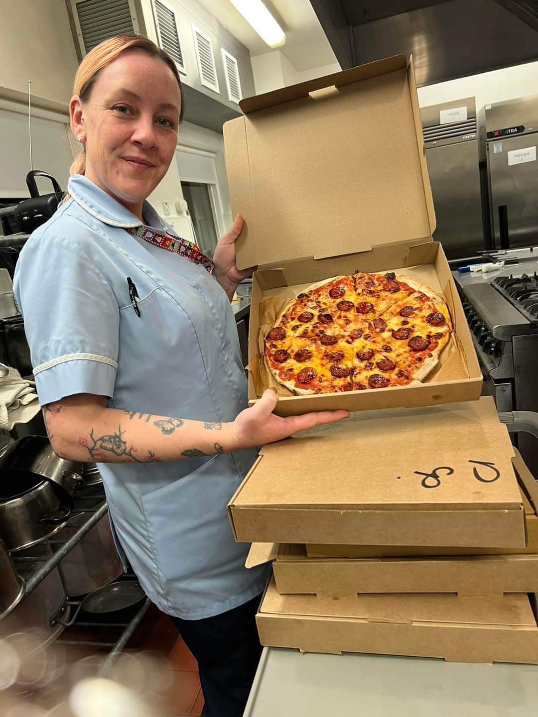 employee holding up pizza box